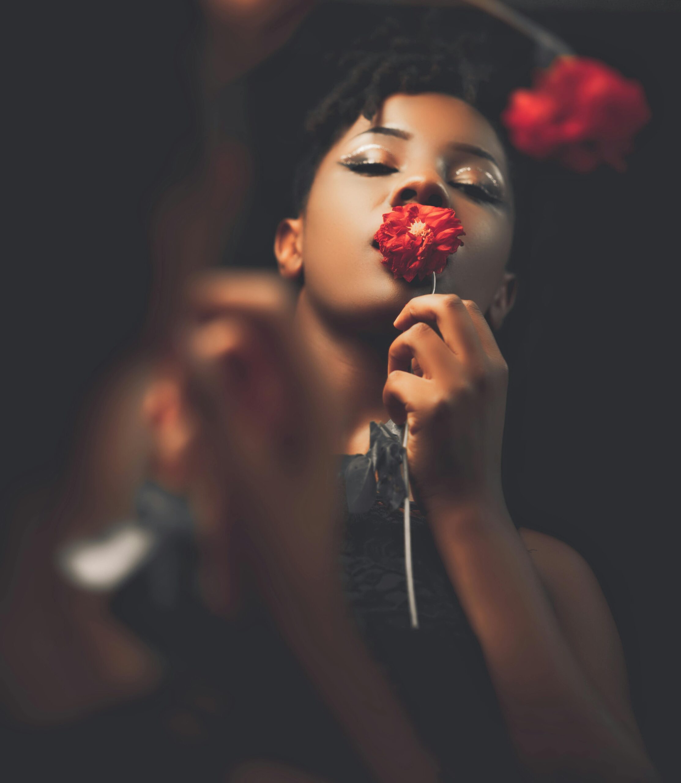 Atmospheric image of a woman smelling a flower.